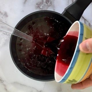 Una persona che versa una salsa in una ciotola con un cucchiaio