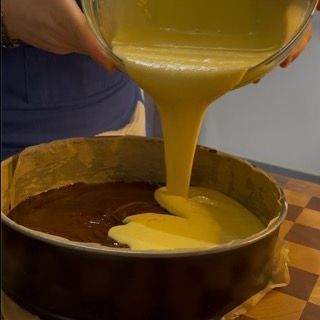 Una persona sta versando del liquido in una tortiera