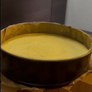 Una ciotola piena di liquido giallo è appoggiata su un tavolo di legno.