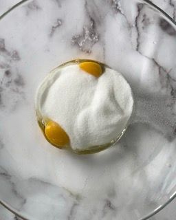 Uova, zucchero e sale in una ciotola, lavorati con una frusta,