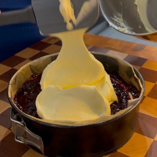 Una torta viene versata in una teglia su un tavolo a scacchi