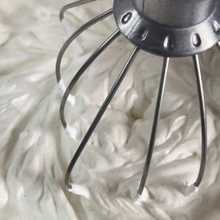 Un primo piano di un mixer con panna montata sopra