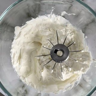 Un primo piano della panna montata in un frullatore su un tavolo.