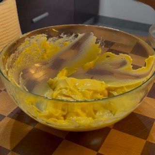 Una ciotola di vetro piena di liquido giallo su un tavolo a scacchi