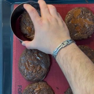 La mano di una persona sta infilando la mano in una ciotola di biscotti al cioccolato
