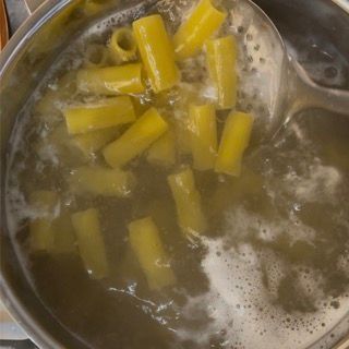 Una pentola di pasta con un cucchiaio dentro