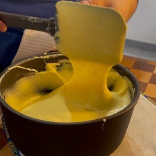 Una persona tiene una spatola sopra una ciotola di liquido giallo