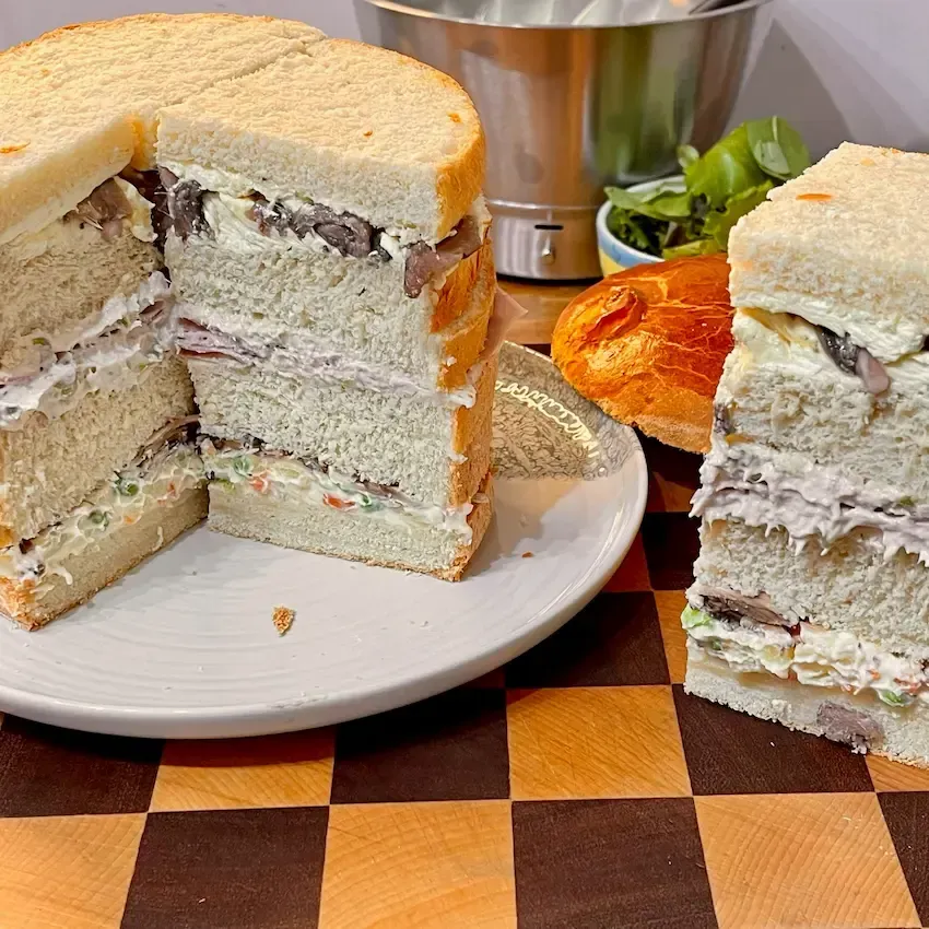 Tre varianti di farcitura per panettone gastronomico: salumi, pesce e gourmet serviti su un tagliere.