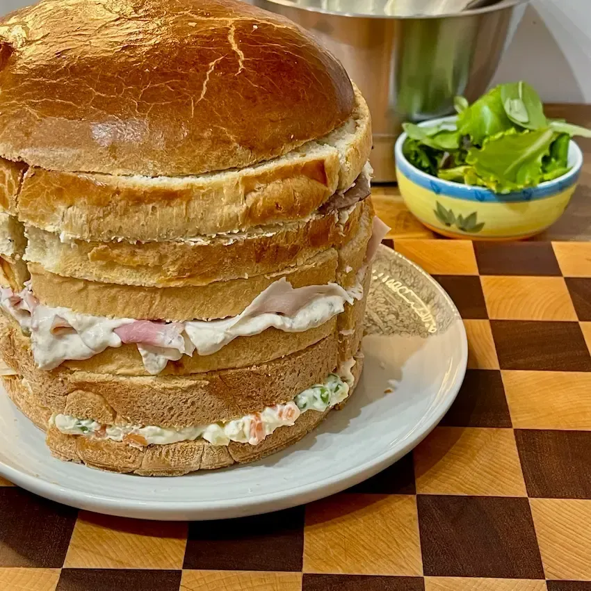 Tre varianti di farcitura per panettone gastronomico: salumi, pesce e gourmet serviti su un tagliere