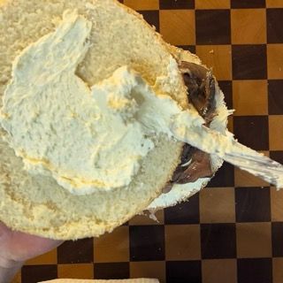 Chiusura dell'ultimo strato con la fetta imburrata rivolta verso il basso.