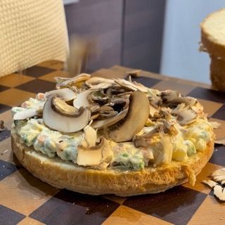 Funghi tagliati sottili con la mandolina sopra l'insalata russa.