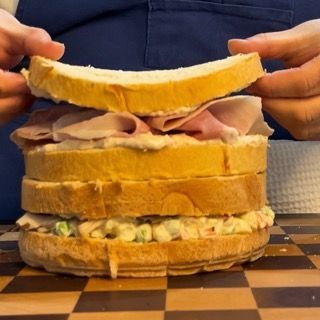 Chiusura del secondo strato con prosciutto e salsa tonnata.