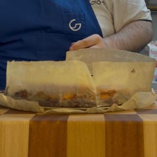 Una persona che indossa un grembiule blu con la lettera g sopra