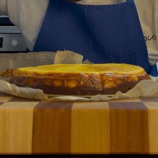 Una cheesecake è appoggiata su un tagliere di legno