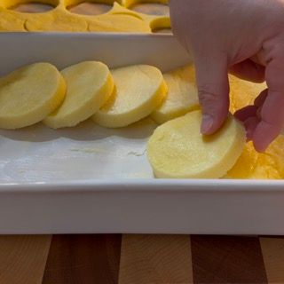 Una persona tiene in mano una fetta di patata.