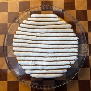 Una torta su un piatto di vetro su un tavolo a scacchi