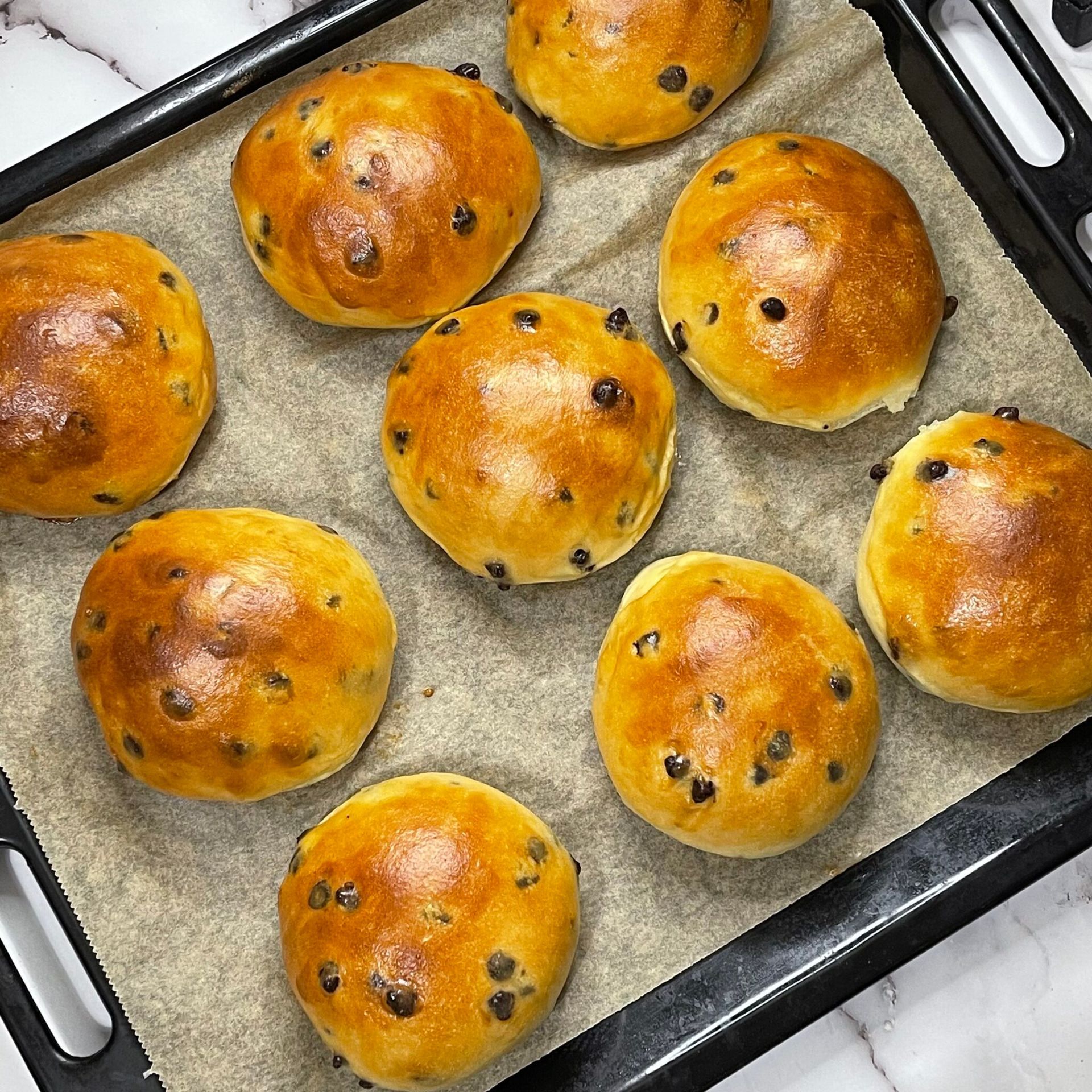 Un mucchio di rotolini di cioccolato sono appoggiati su una teglia da forno.
