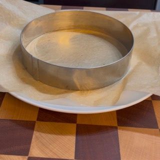 Un anello di metallo su un piatto bianco su un tavolo a scacchi