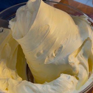 Una ciotola di panna montata è appoggiata su un tavolo.