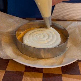 Una persona sta versando la glassa in una torta su un piatto