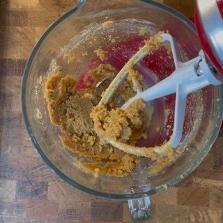 Un mixer sta mescolando una sostanza marrone in una ciotola di vetro