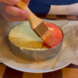 Una persona sta spennellando una torta con un pennello