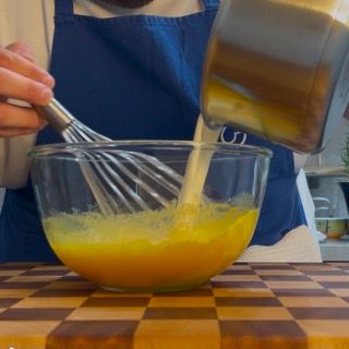 Una persona sta versando del liquido in una ciotola con una frusta