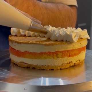 Una persona sta glassando una torta con panna montata