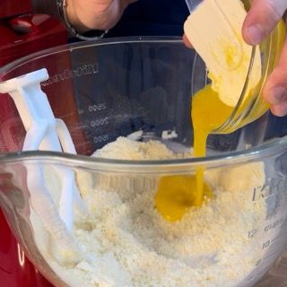 Tuorli d'uovo versati nell'impasto della frolla