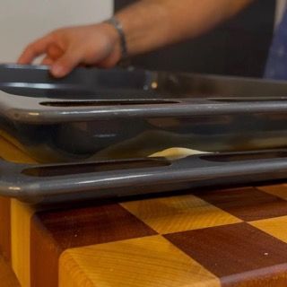 Due vassoi sono appoggiati su un tagliere di legno