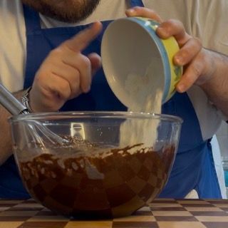 Un uomo sta versando del liquido in una ciotola di cioccolato