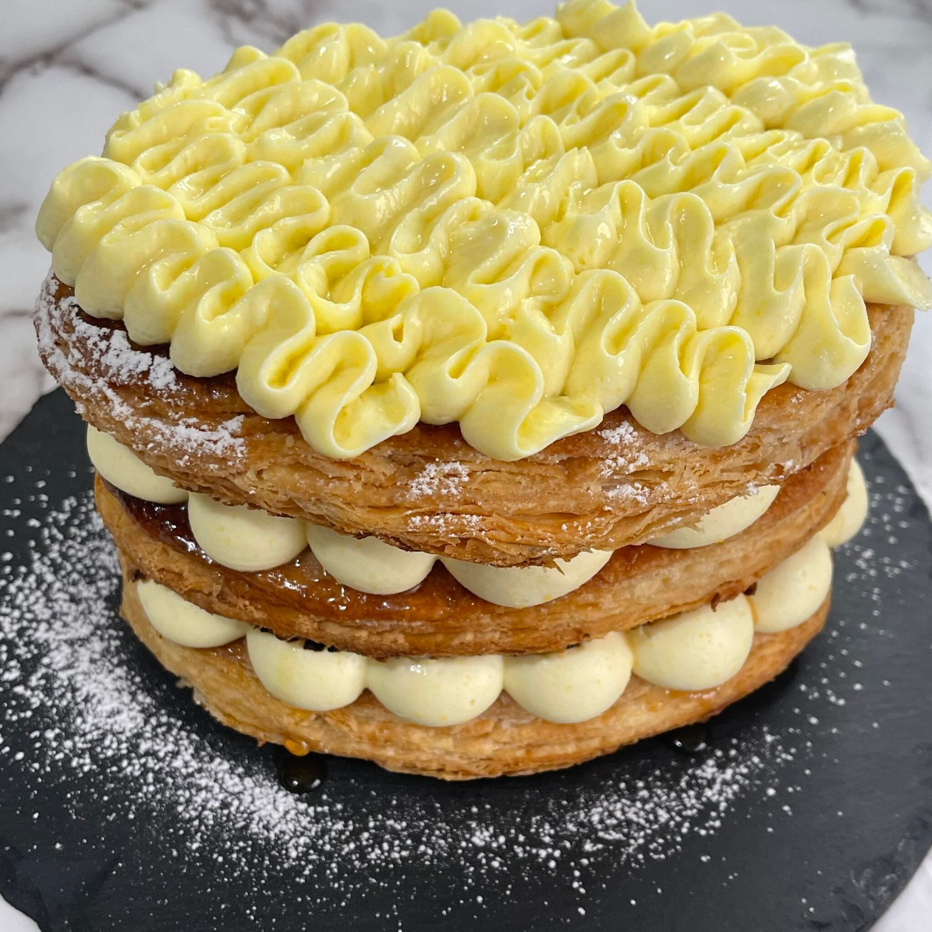 Un primo piano di una torta con zucchero a velo sopra su un tavolo.