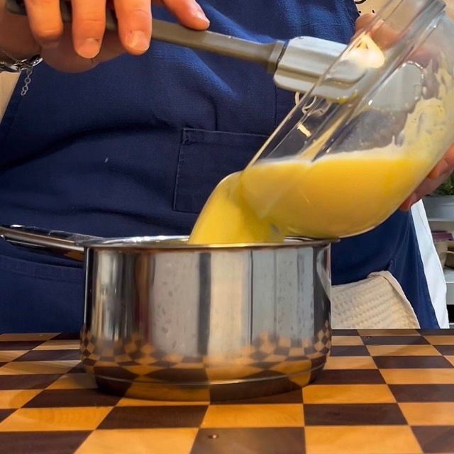 La crema inglese che viene versata in un pentolino per essere cotta