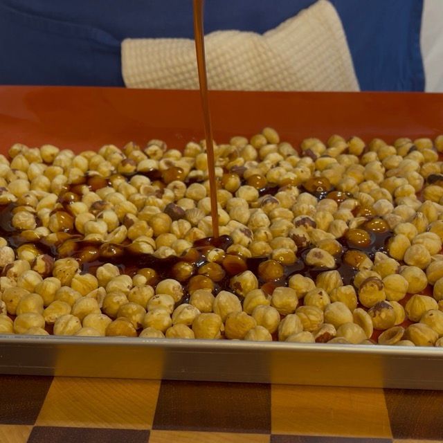 Caramello ambrato versato sulle nocciole tostate