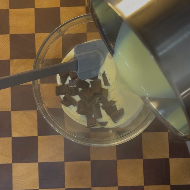 Crema inglese calda versata sul cioccolato fondente