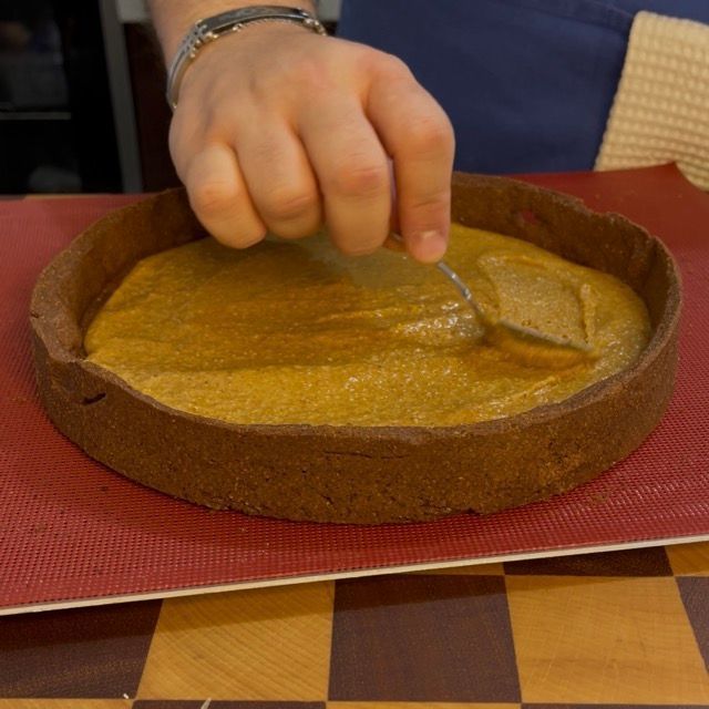 Strato di pralinato alla nocciola sul fondo del guscio di frolla