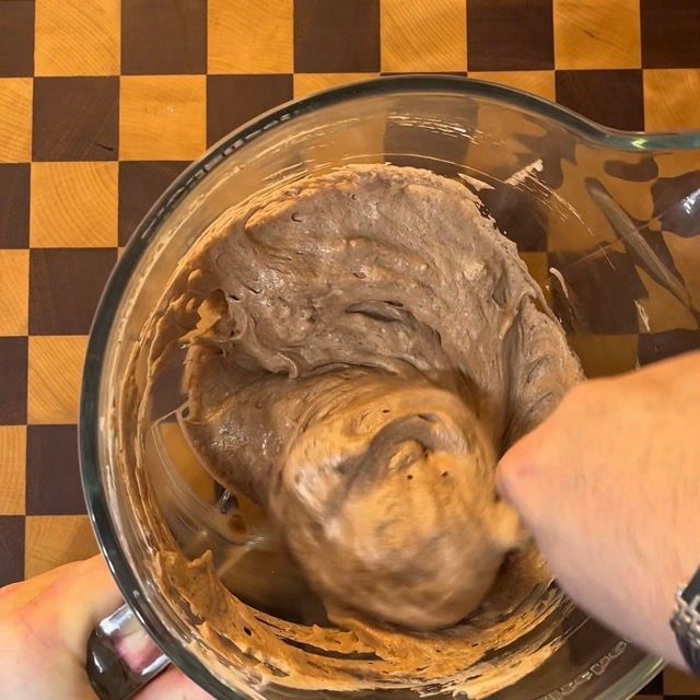 Spatola che mescola delicatamente l'impasto del biscuit dal basso verso l'alto