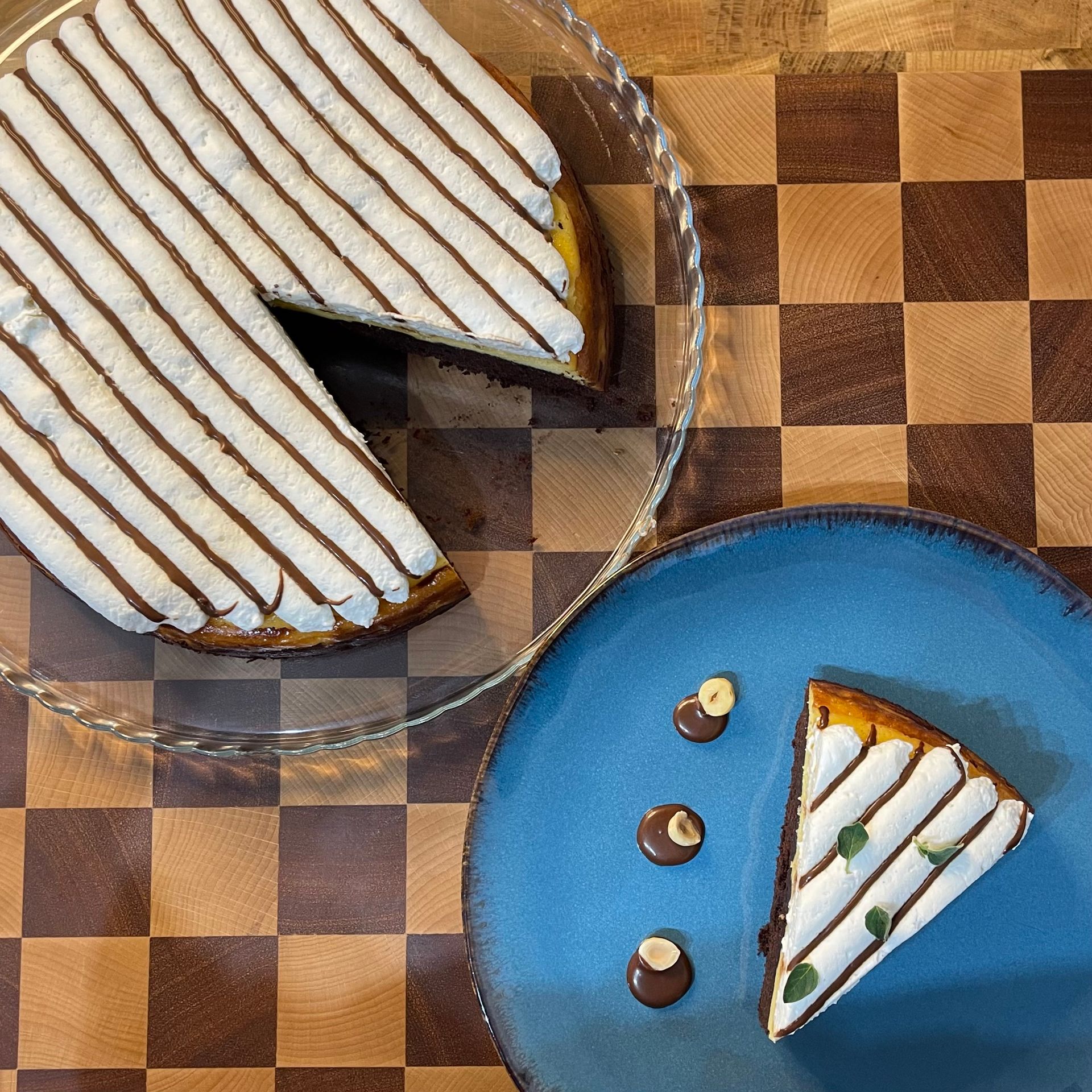 Una fetta di torta è su un piatto blu accanto a un pezzo di torta