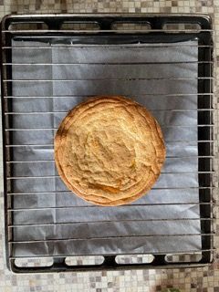 Un biscotto è appoggiato su una griglia sopra una padella.