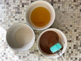 Tre ciotole contenenti ingredienti diversi sono appoggiate su un tavolo.