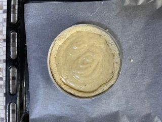 Una torta è appoggiata su una teglia da forno ricoperta di carta da forno.