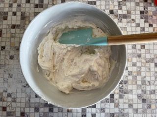 Una ciotola di pastella con una spatola dentro su un tavolo.