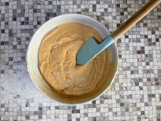 Una ciotola di pastella con una spatola dentro su un tavolo.