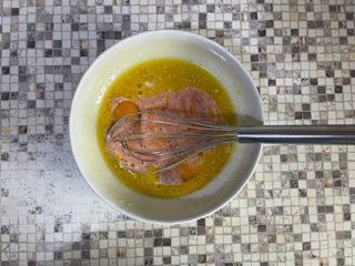 Una ciotola di cibo con una frusta dentro su un tavolo.