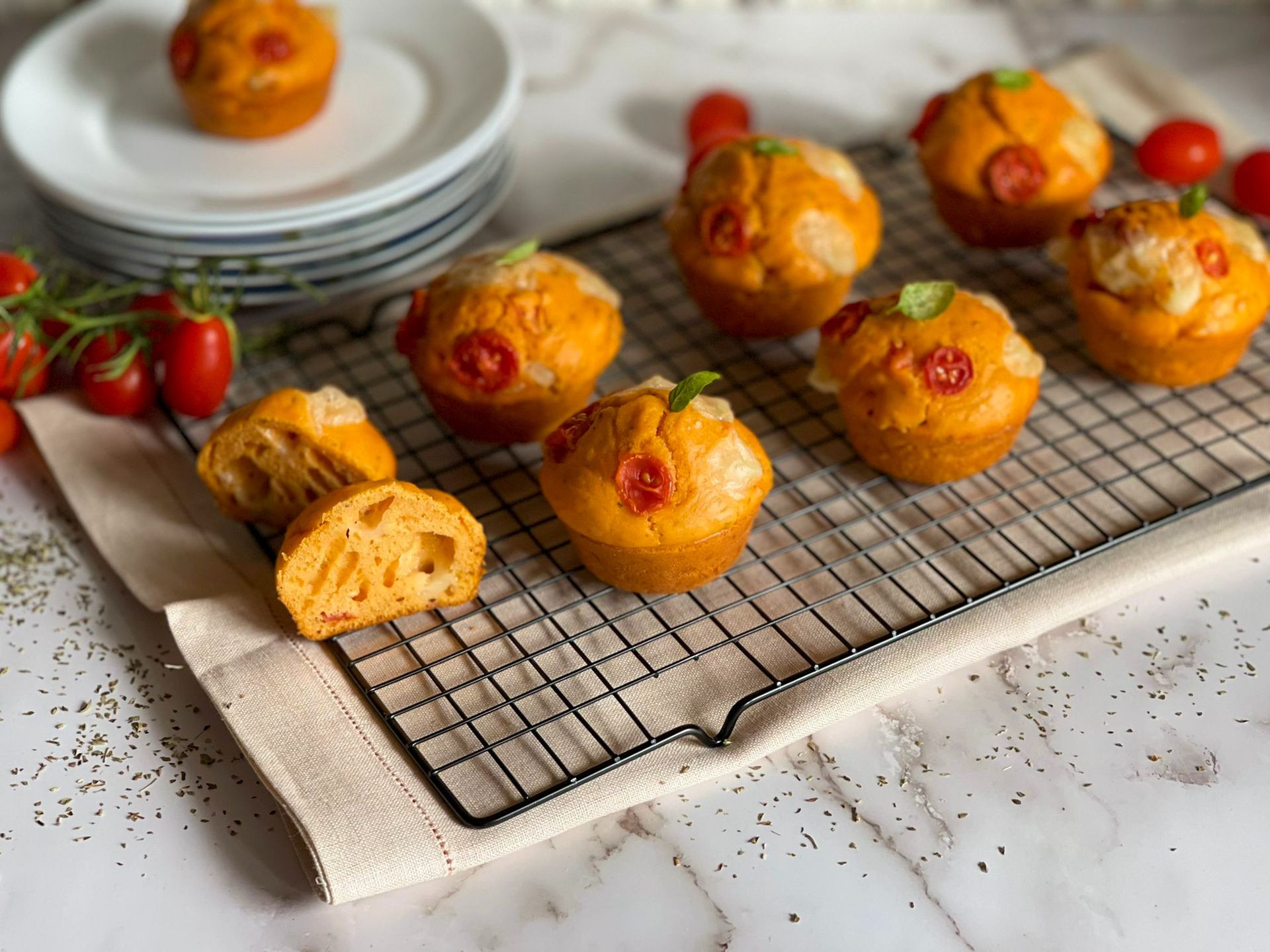 Un mucchio di muffin appoggiati su una griglia di raffreddamento.