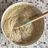 Una ciotola di pastella con una spatola dentro su un tavolo.