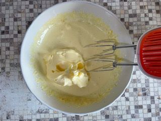 Una ciotola di pastella con dentro un mixer su un tavolo.