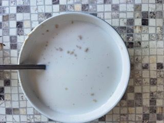 Una ciotola di zuppa con un cucchiaio dentro su un tavolo.