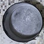 Una ciotola nera è appoggiata su un tavolo a scacchi.