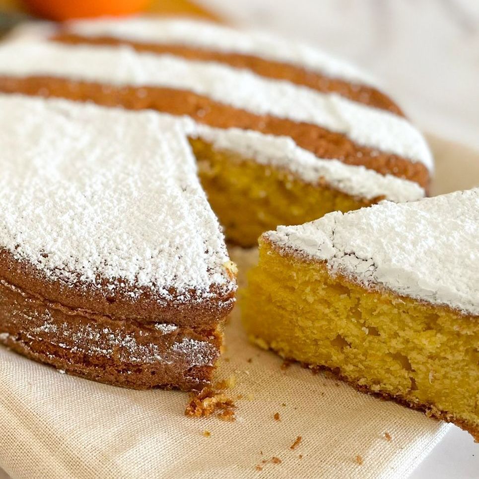 Un pezzo di torta ricoperto di zucchero a velo è appoggiato su un tovagliolo su un tavolo.
